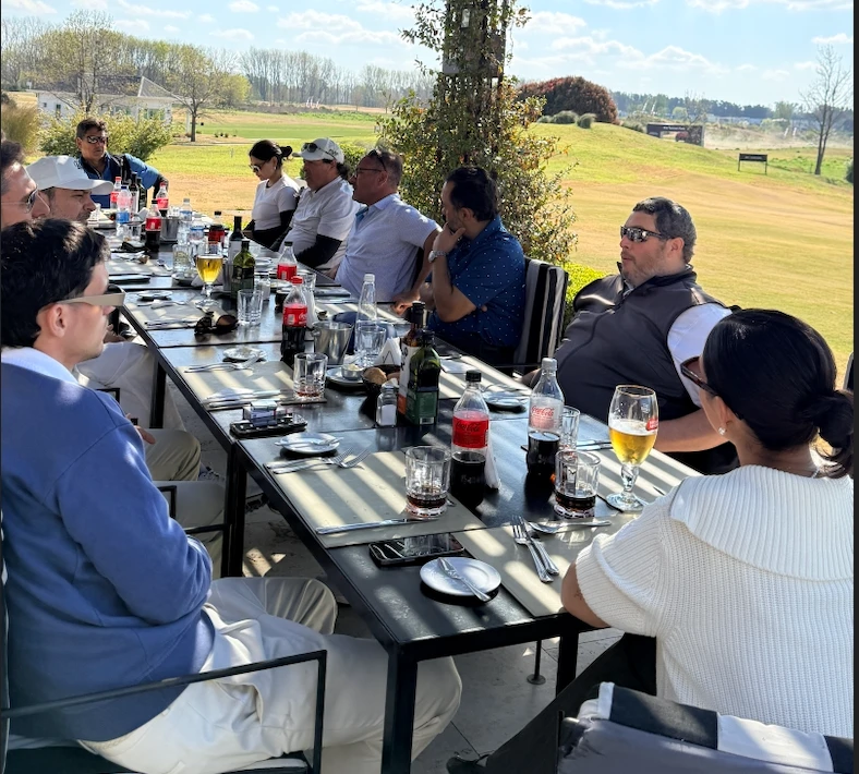 Grupo almorzando en una mesa larga en el Club House de Pilará